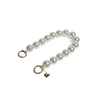 Side display of pearl wristlet strap with golden clasps separated, for secure wearing.