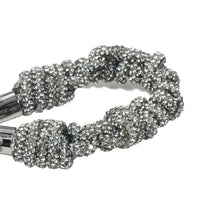 Detailed texture of shimmering crystal braids with silver hardware